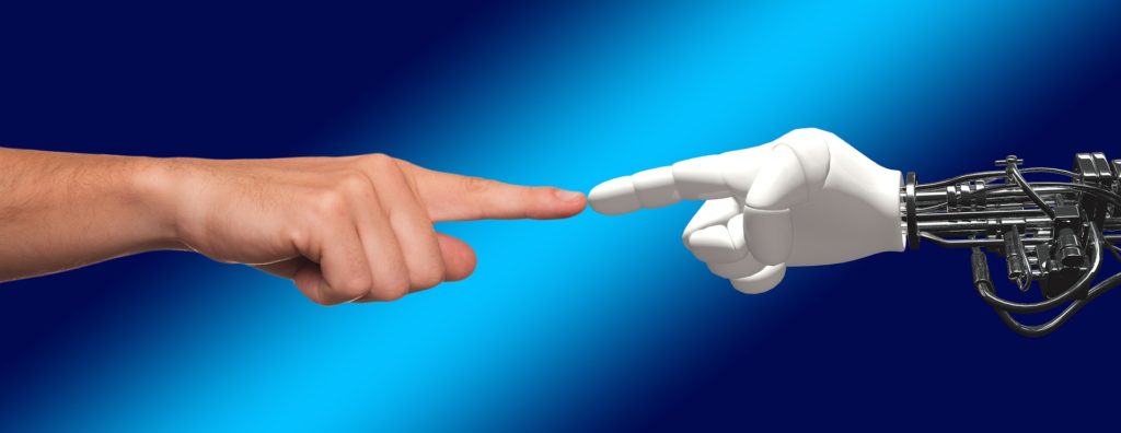 A human hand touching the finger of a robot hand