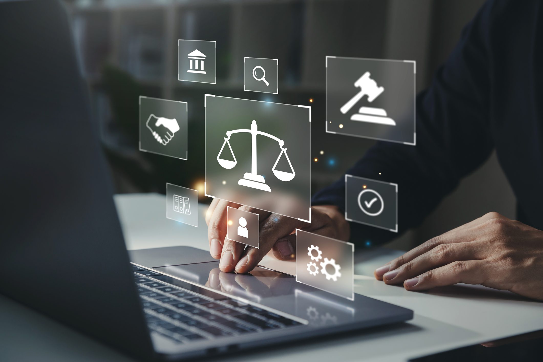 Hand of human with legal services icon on laptop screen.