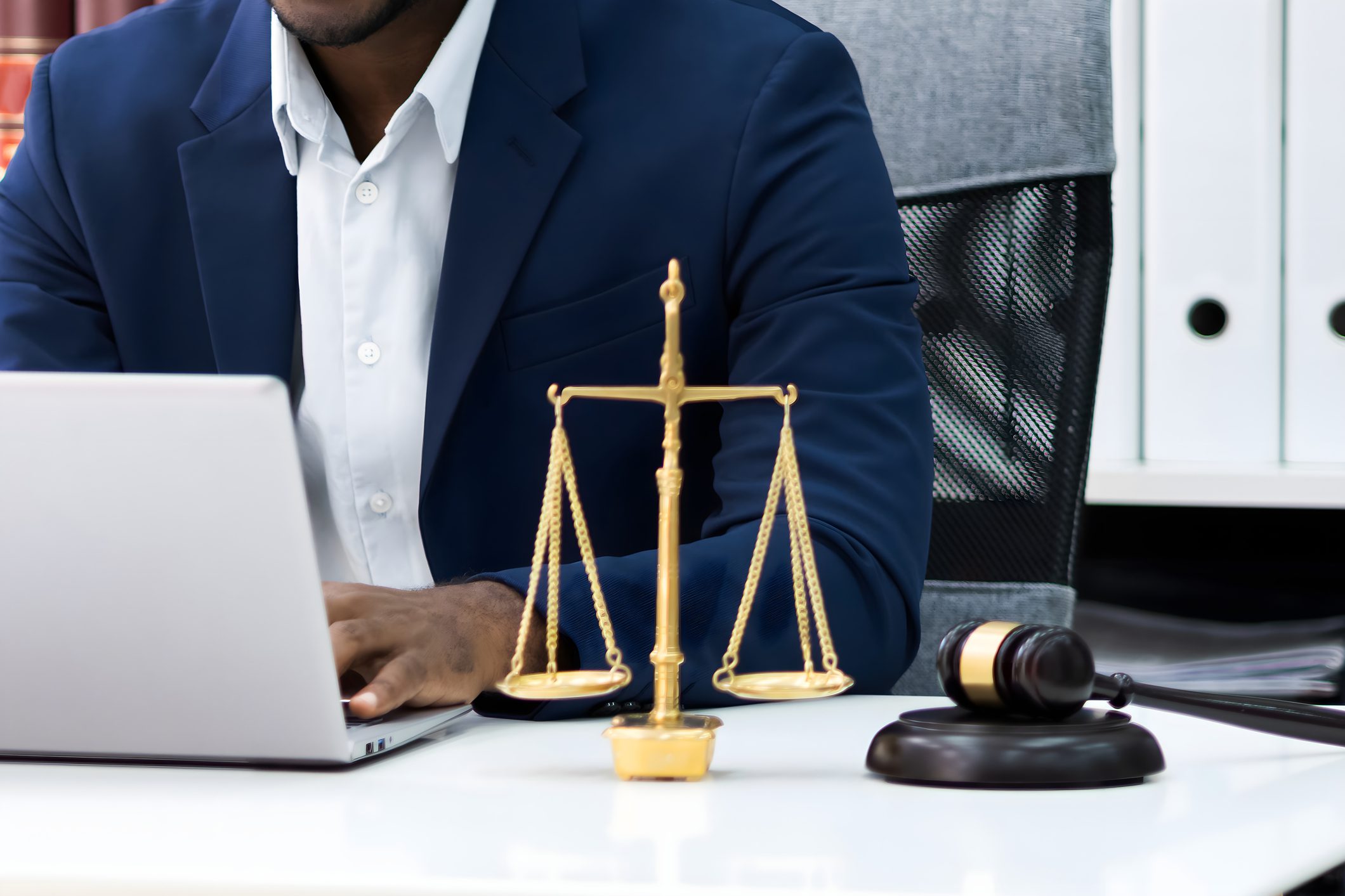 Professional legal workspace with scales of justice, a gavel, and laptop, representing the balance between law firm expertise and digital content strategy.
