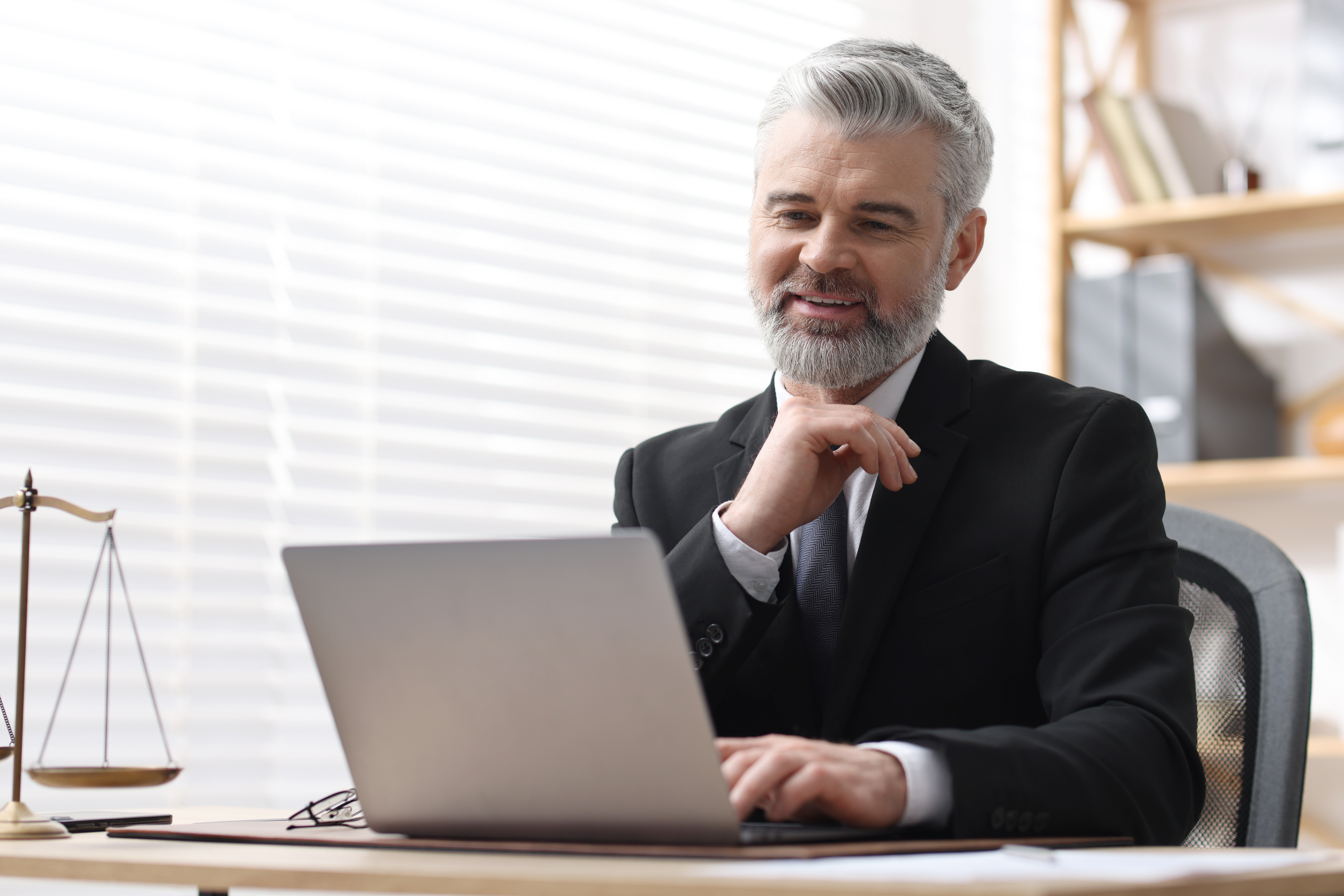 Law firm professional using a laptop to review SEO, AEO, and GEO strategy.