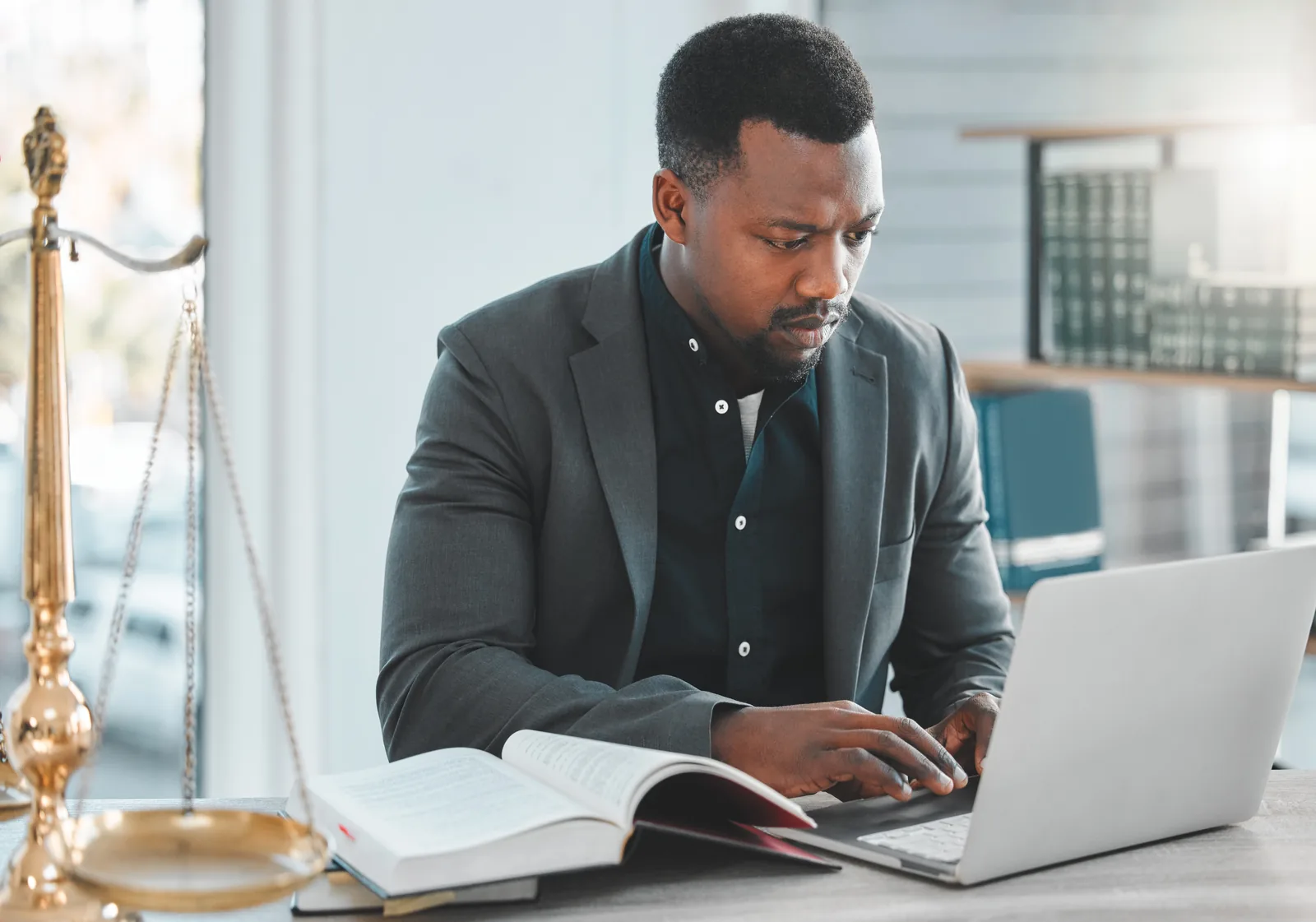"Attorney reviewing family law competitors in AEO and GEO research on a laptop beside an open law book and scales of justice