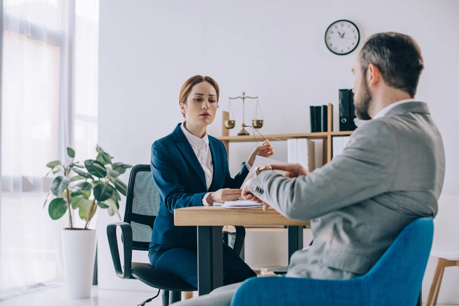 Family law attorney and client reviewing documents across a desk in a law office