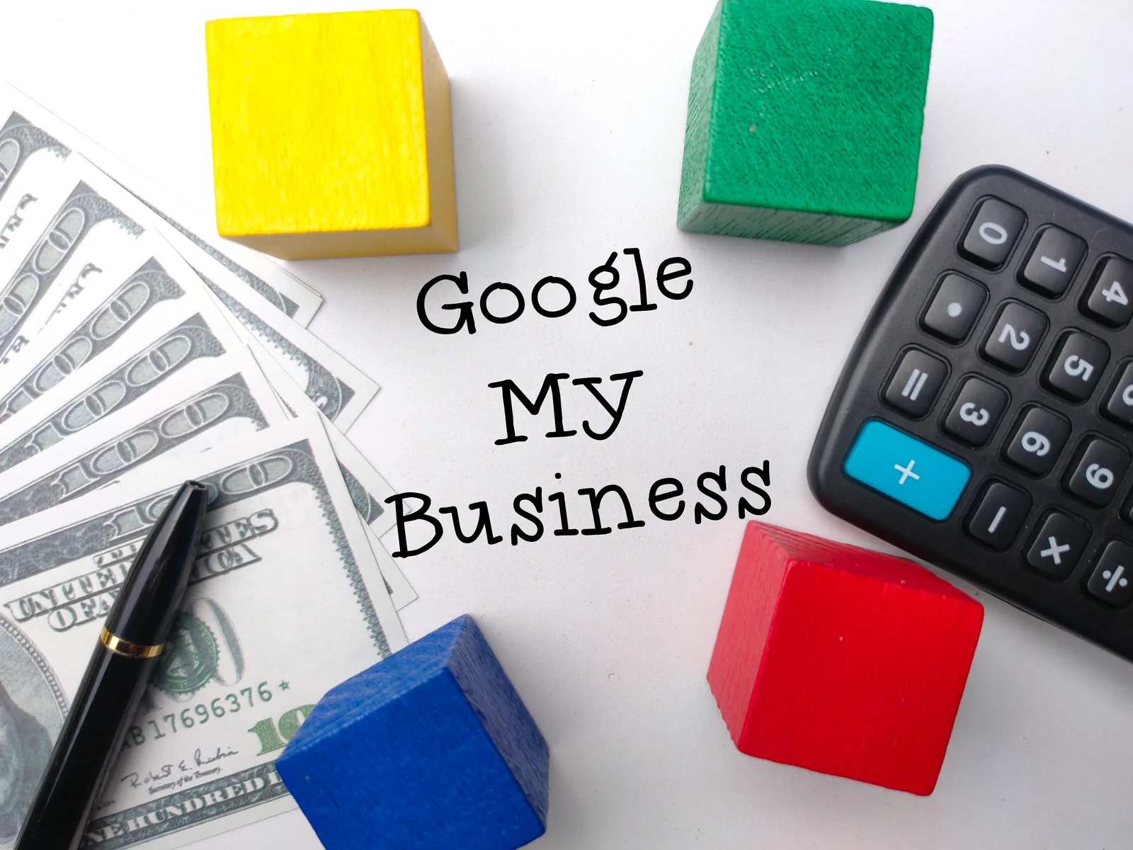 Google My Business written on paper with cash, a calculator and colored blocks