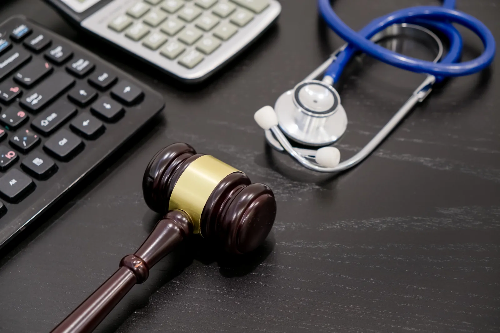 Gavel beside a stethoscope and calculator, representing medical malpractice law