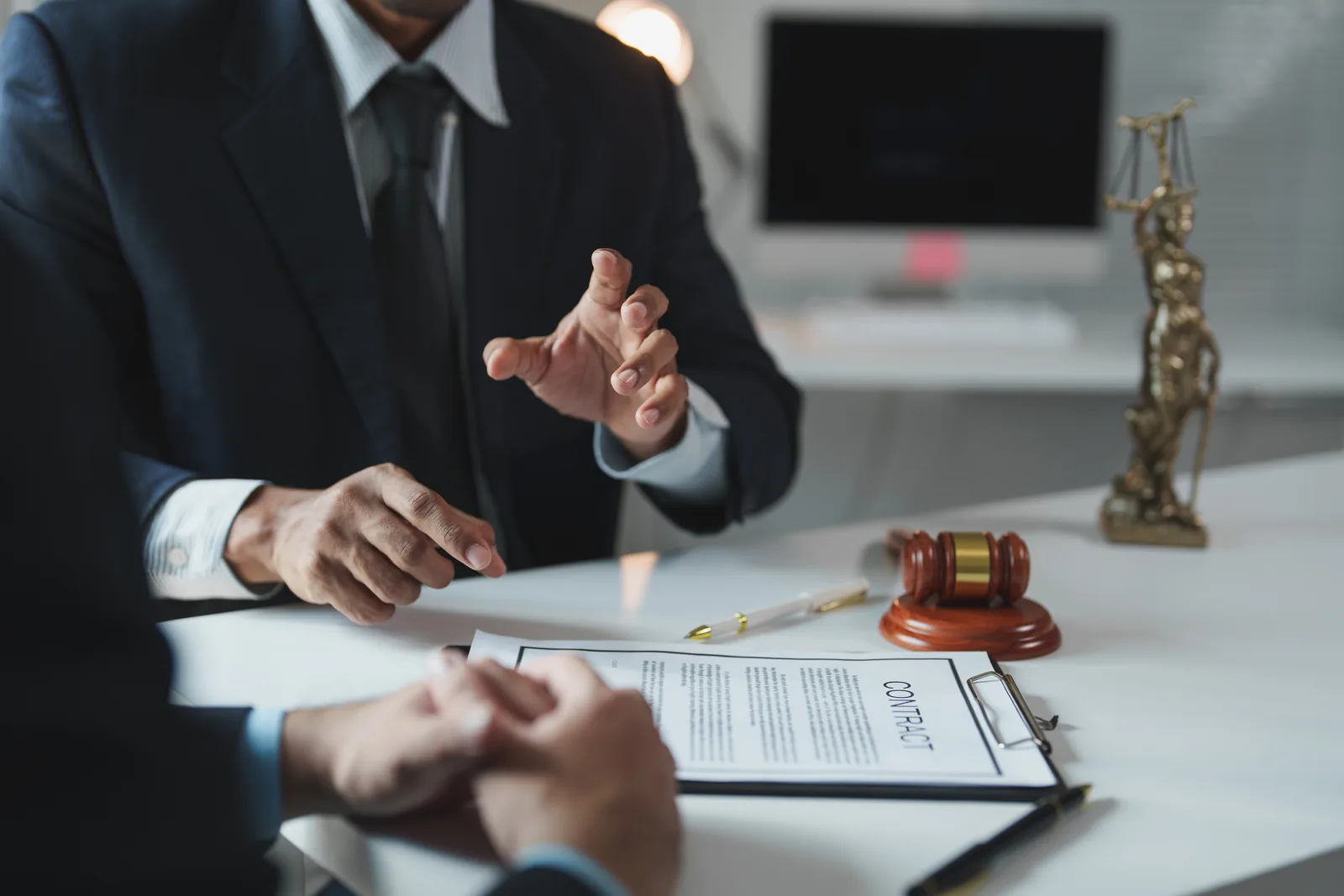 Attorney reviewing a contract with a client across a desk