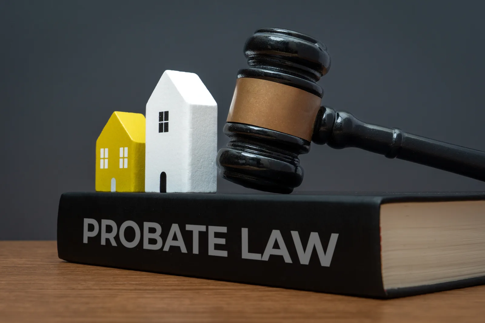 Gavel and two model houses resting on a probate law book