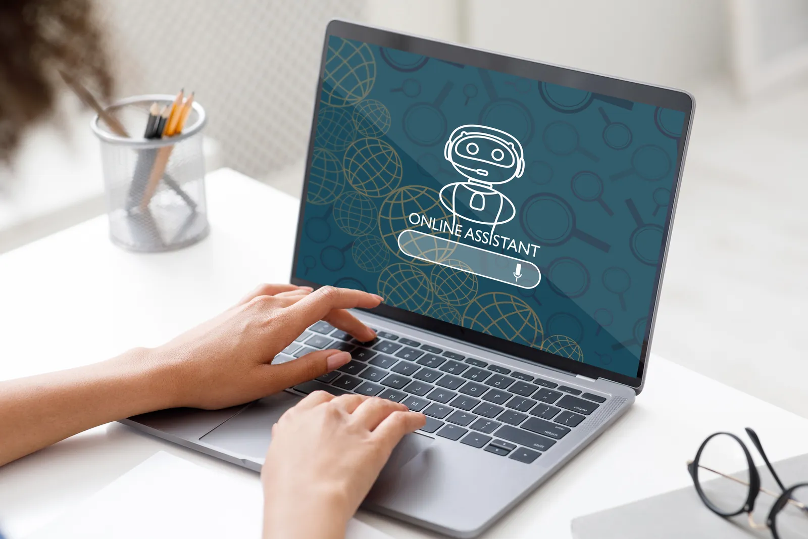 Hands typing on a laptop showing an online AI assistant screen