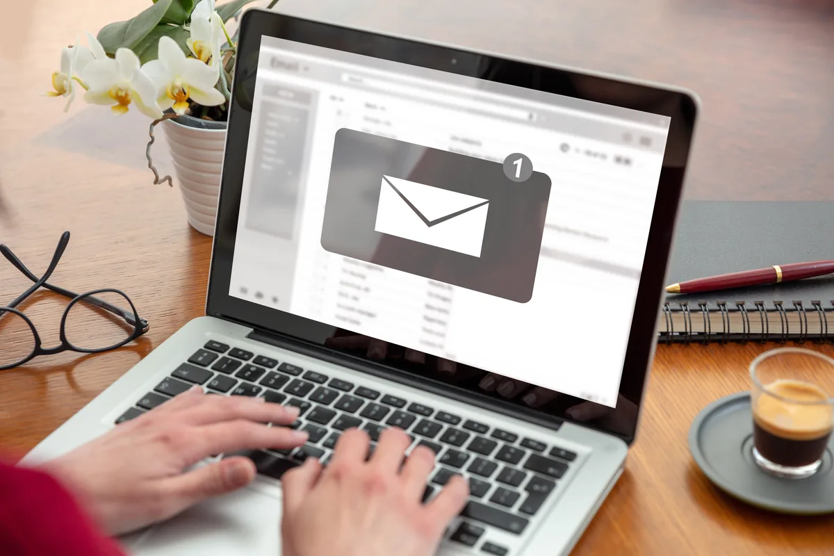 Law firm email newsletter: hands typing on a laptop showing a new email in the inbox