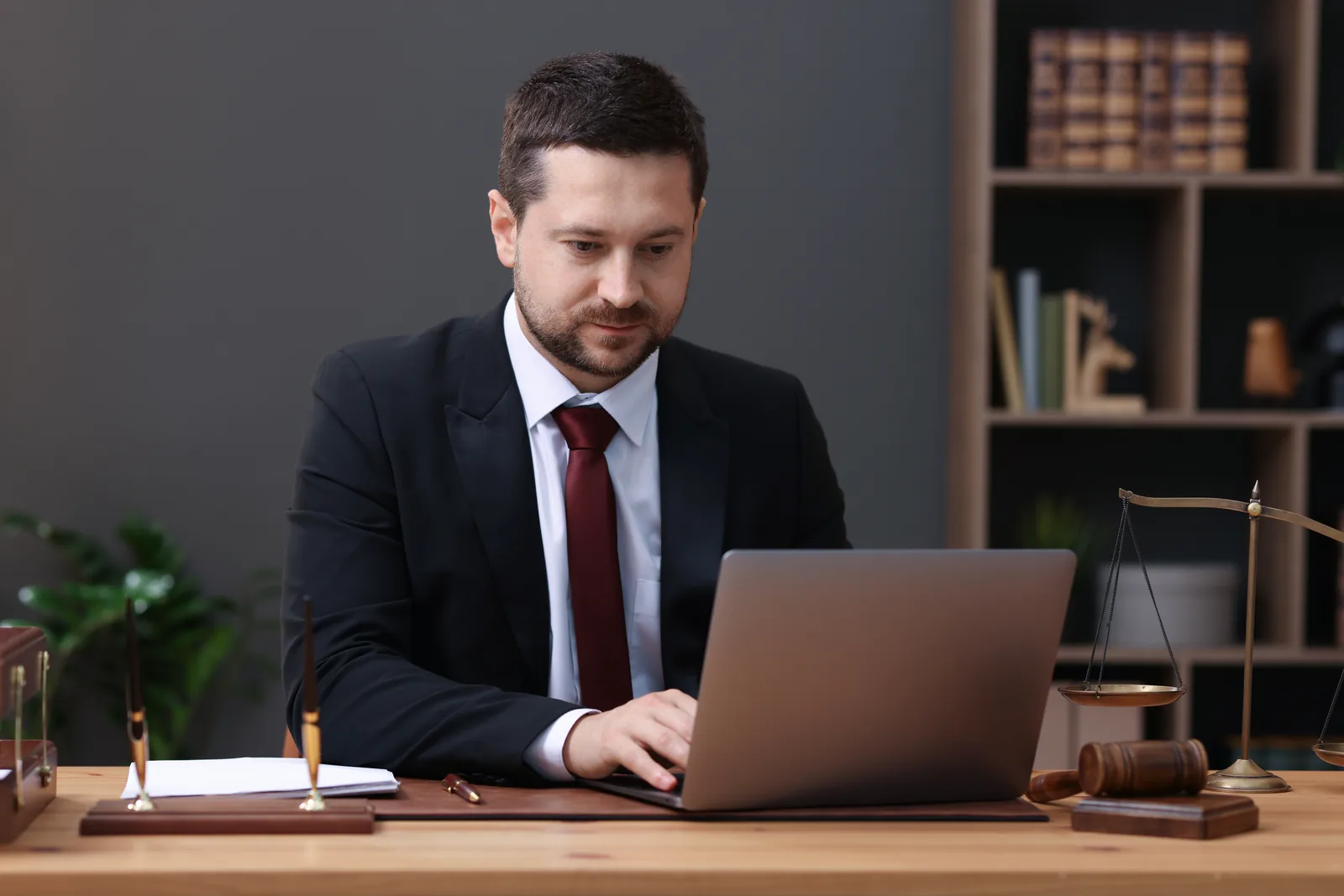 LinkedIn for lawyers: attorney in a suit working on a laptop in a law office