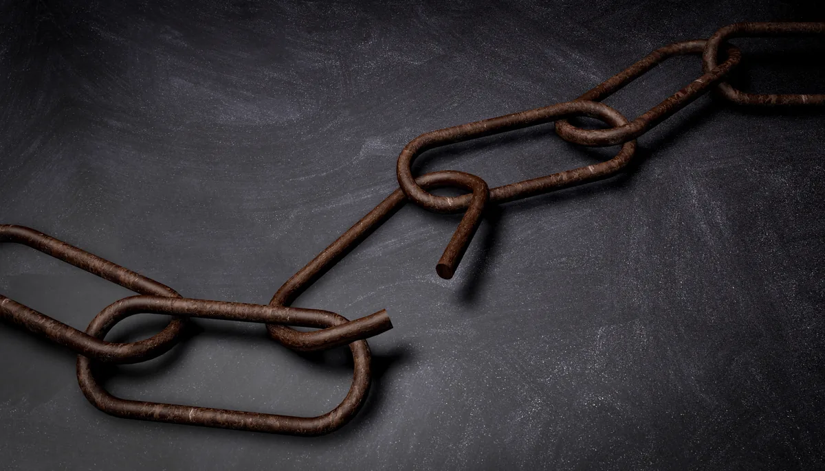 Niche edits for law firms: broken rusty chain links on a dark gray surface